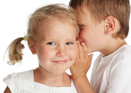Deux enfants qui se disent un secret et qui réussissent à communiquer grâce aux services en orthophonie pour enfants et speech language services for children