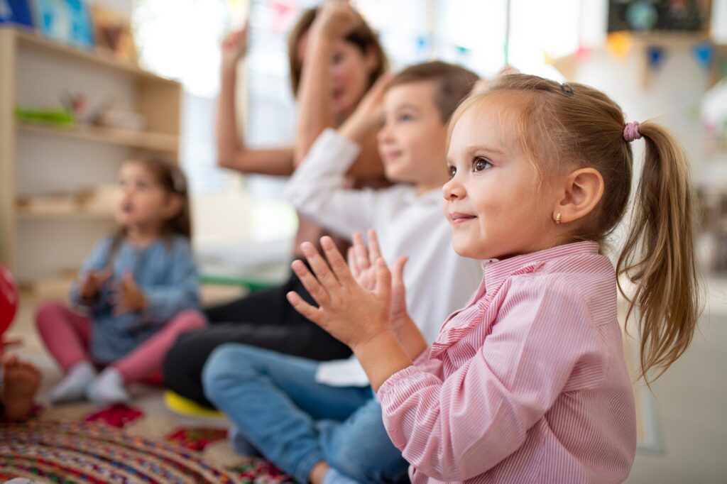 Une jeune fille qui participe dans sa classe de maternelle grâce aux services en orthophonie pour enfants et speech language services for children