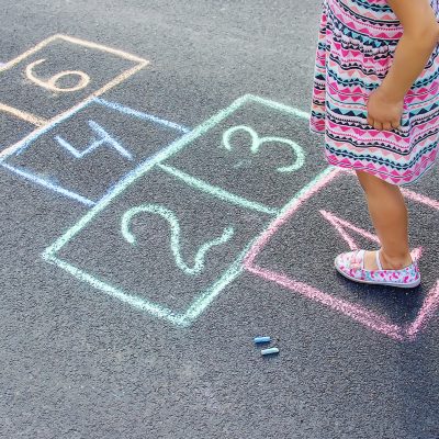 Jeune fille qui joue à la marelle. Elle avance pas à pas comme en thérapie à la clinique avec service de psychologues et orthophonistes Vaudreuil